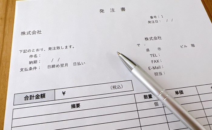 紙の発注書とペン