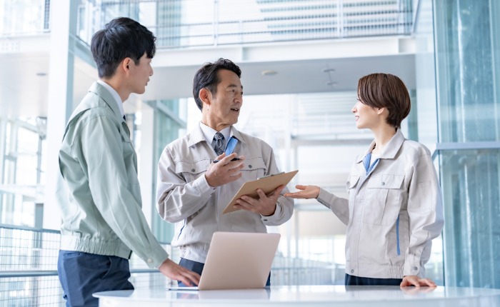 3人で談笑する作業着を着た従業員