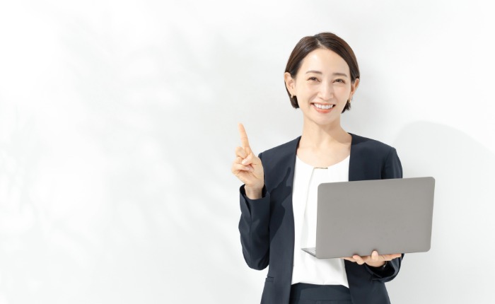 ノートパソコンを持った笑顔のビジネスパーソン